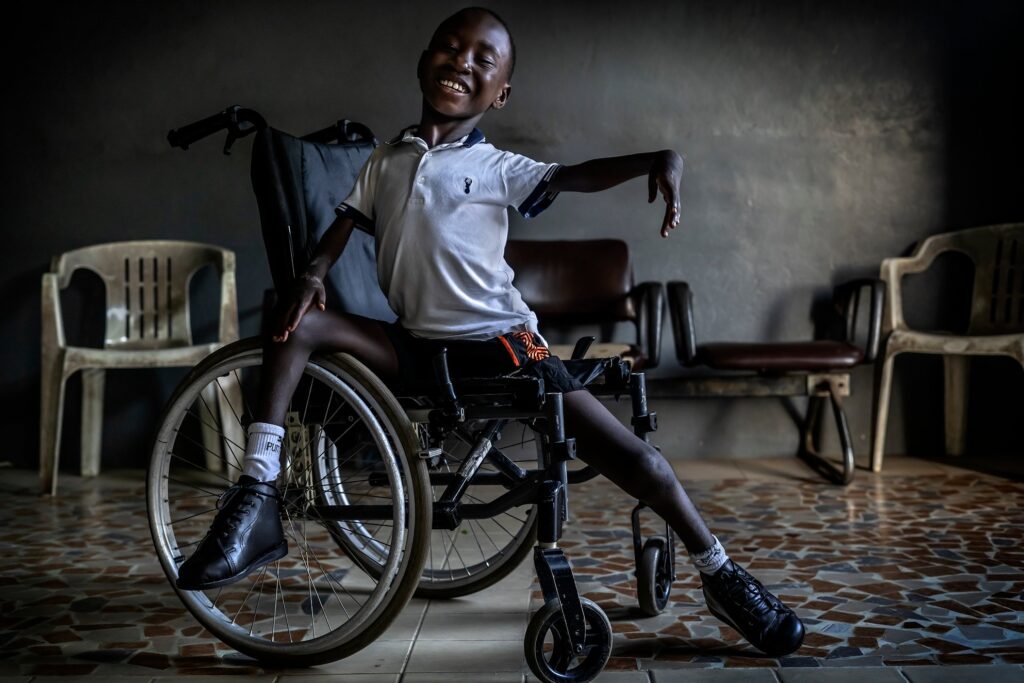 Ivan, an 8-year-old boy from Côte d'Ivoire, dances joyfully in his wheelchair just before receiving new orthopedic devices, tools that will help to live and move independently after years of surgeries and rehabilitation.
