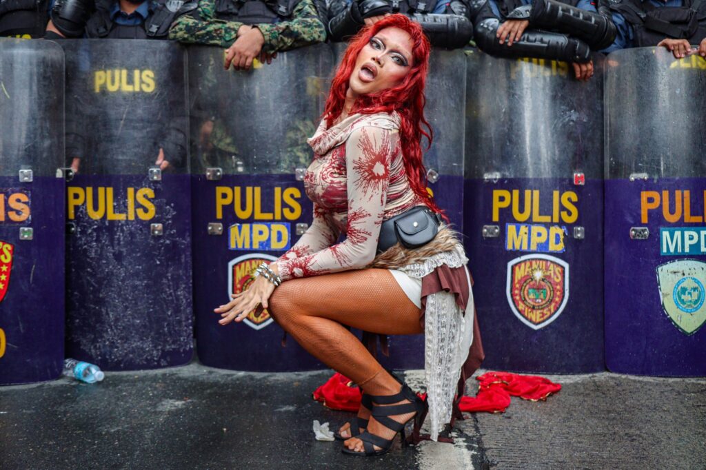 Filipina drag queen Gabriela She Lang, named in tribute to the revolutionary Gabriela Silang, performs before policemen in riot gear during a protest in Manila, part of a movement known as Stonewall Philippines.