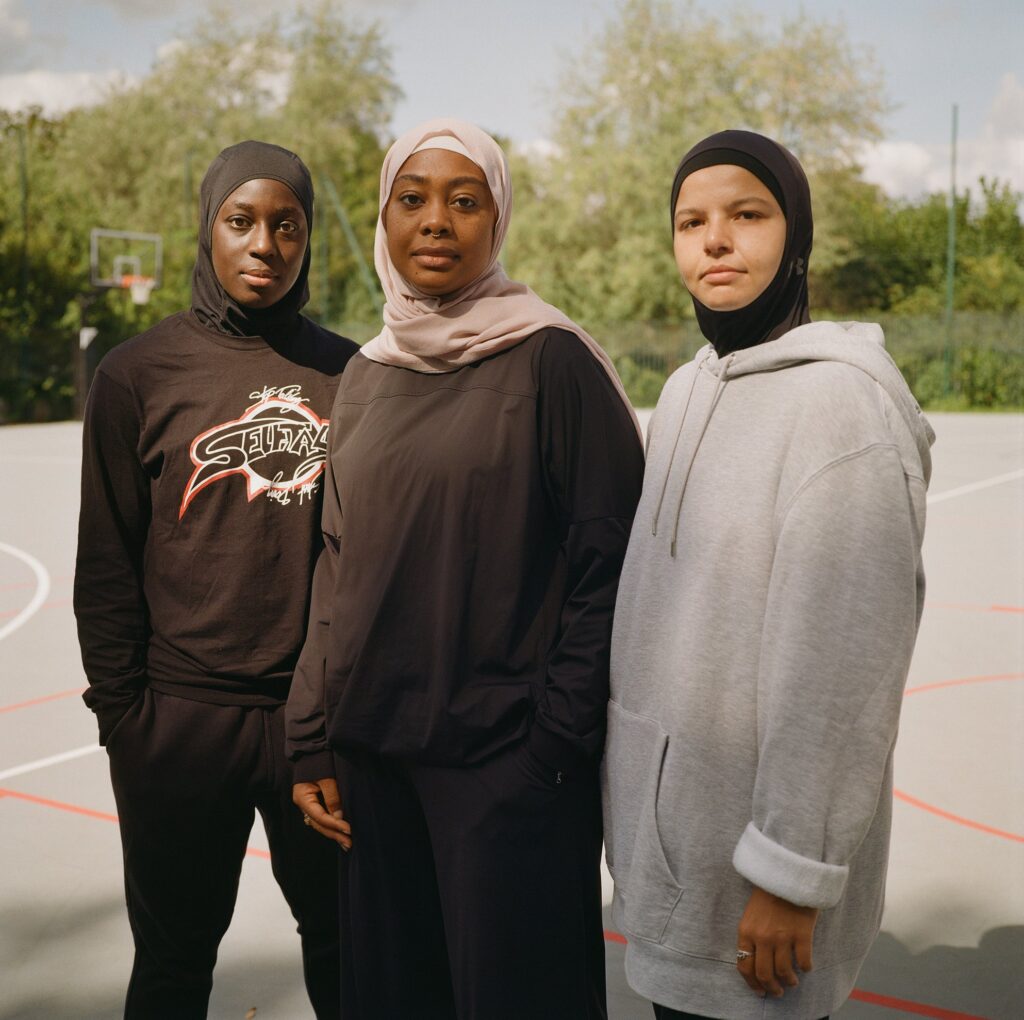 Diaba, Zoulfat and Assia pose on a public basketball court, one of the few places where they can still train wearing the hijab in France.