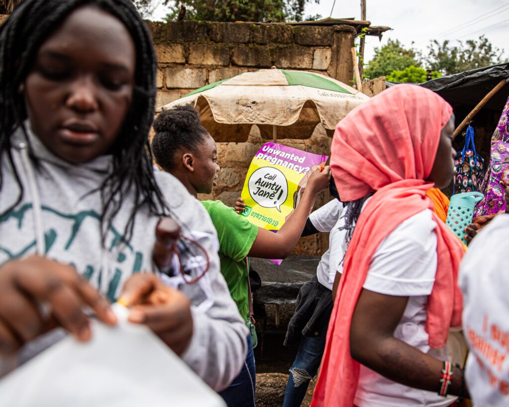 In the heart of Nairobi’s informal settlements, women reclaim justice where the law fails them. A public poster offering help for unwanted pregnancies interrupts the rhythm of the street, challenging both stigma and restrictive laws around reproductive rights.